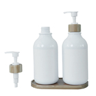 Bouteille blanche de lotion de salle de bains avec la pompe en bambou pour le lavage de shampooing et de corps