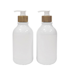 Bouteille blanche de lotion de salle de bains avec la pompe en bambou pour le lavage de shampooing et de corps